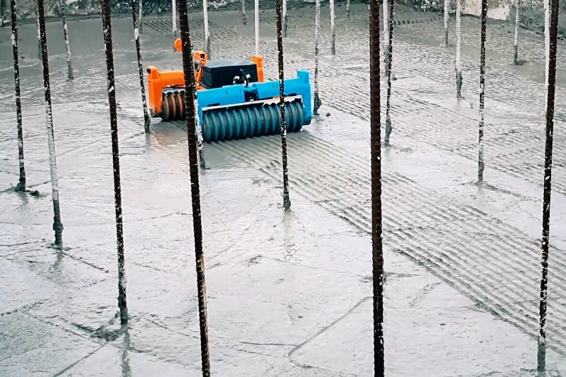 An integrated mechanism keeps the robot's wheels from getting clogged with concrete sludge