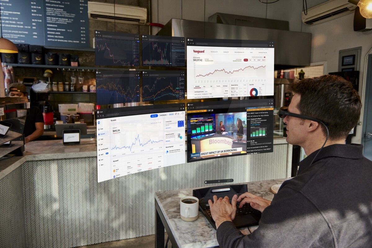 Man working in coffee shop with transparent computer screen in front of him