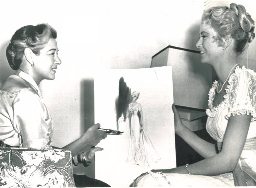 Helen Rose and Grace Kelly discussing the dress she wore in her 'wedding of the century' to Prince Rainier III of Monaco in April, 1956. Kelly is wearing the dress to be auctioned. Lot 196 at Bonhams and TCM "Treasures from the Dream Factory Auction, 23 November, 2015 (New York)
