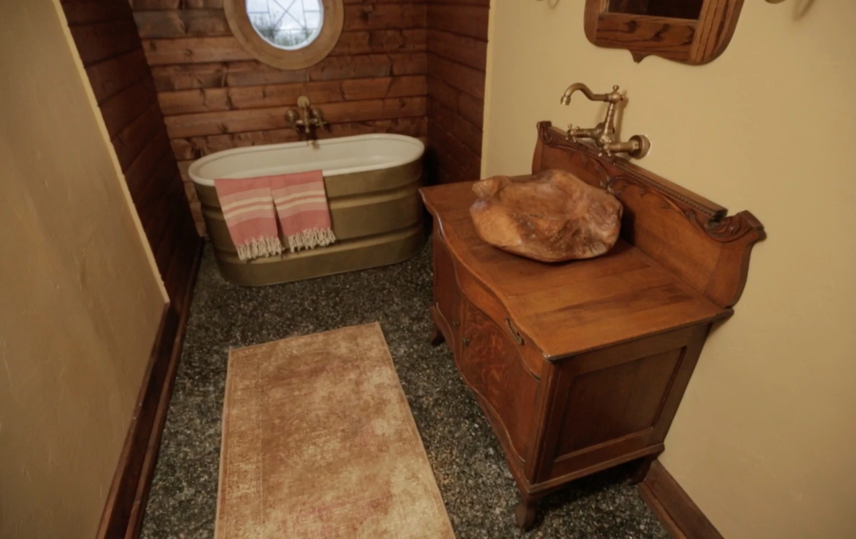 The interior includes authentic-looking touches like a cordwood floor, bespoke lighting, and even a woodworking bench and tools to whittle