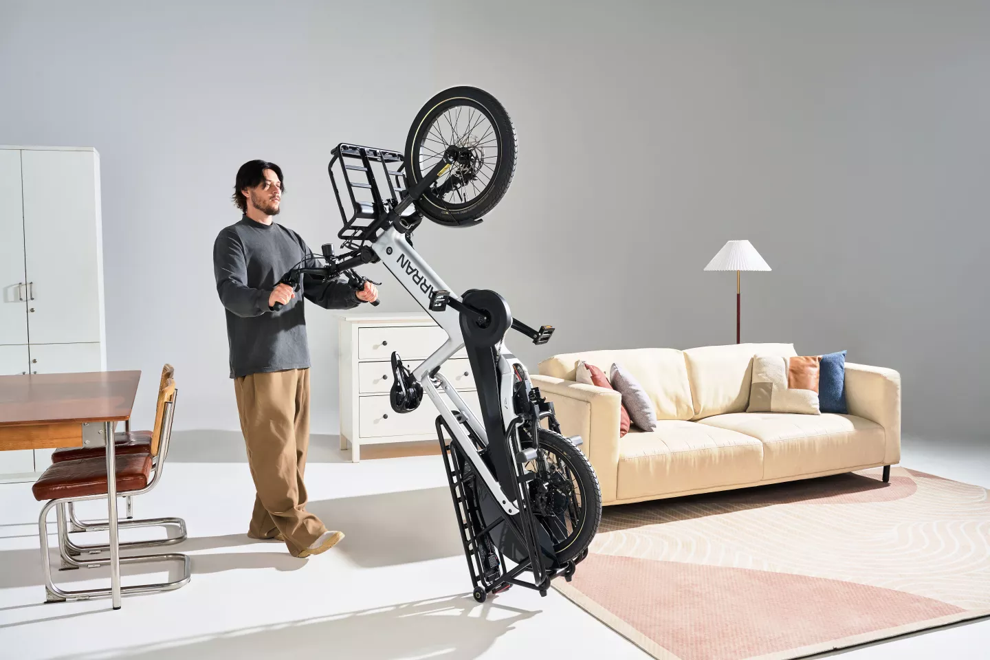 The Tarran L1 Series cargo ebike can be wheeled to its storage spot in the apartment on rack-mounted mini wheels, keeping dirty tires off the carpet