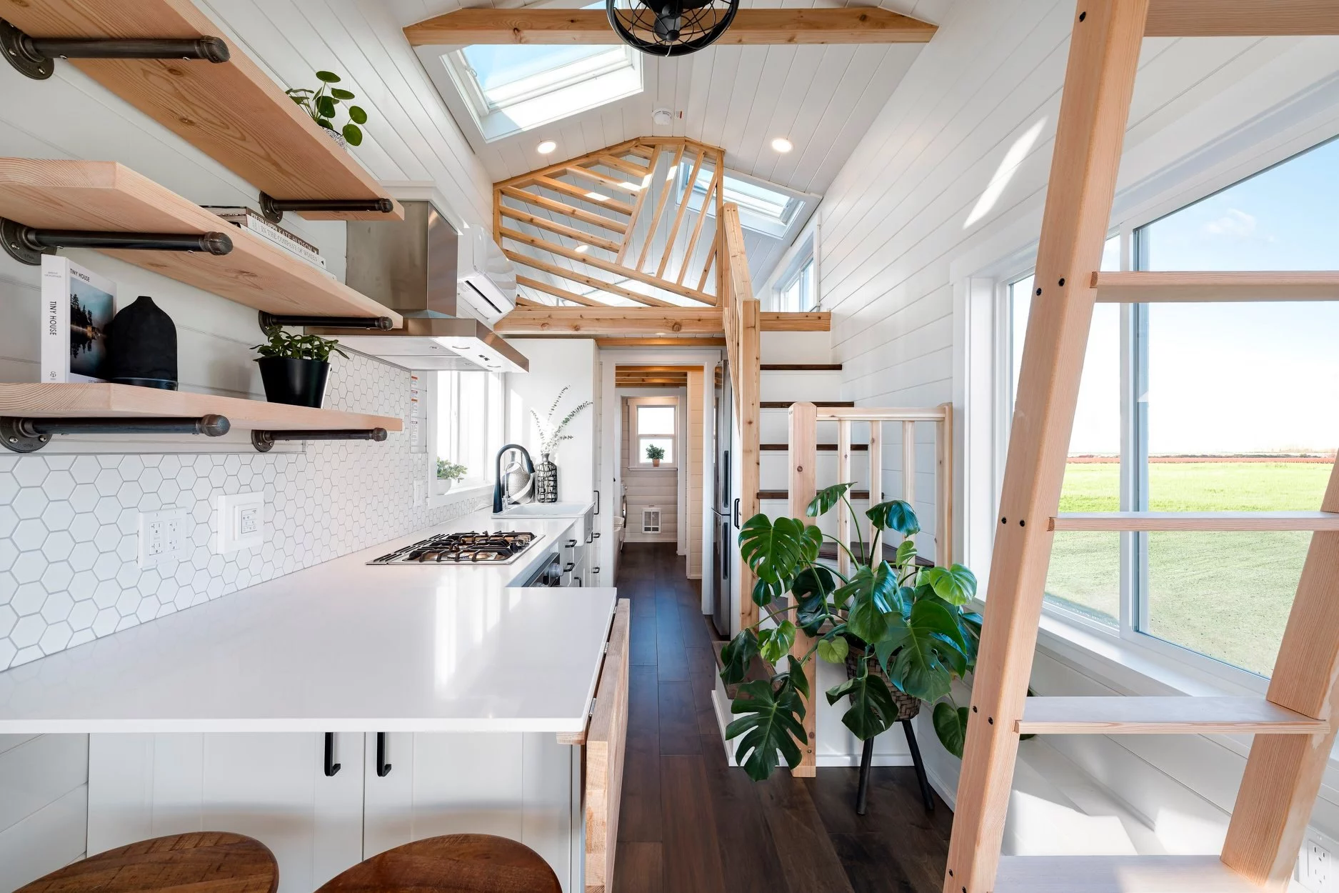 The 34ft Eco-Friendly Tiny House RV's kitchen includes a breakfast bar with stool seating for two people