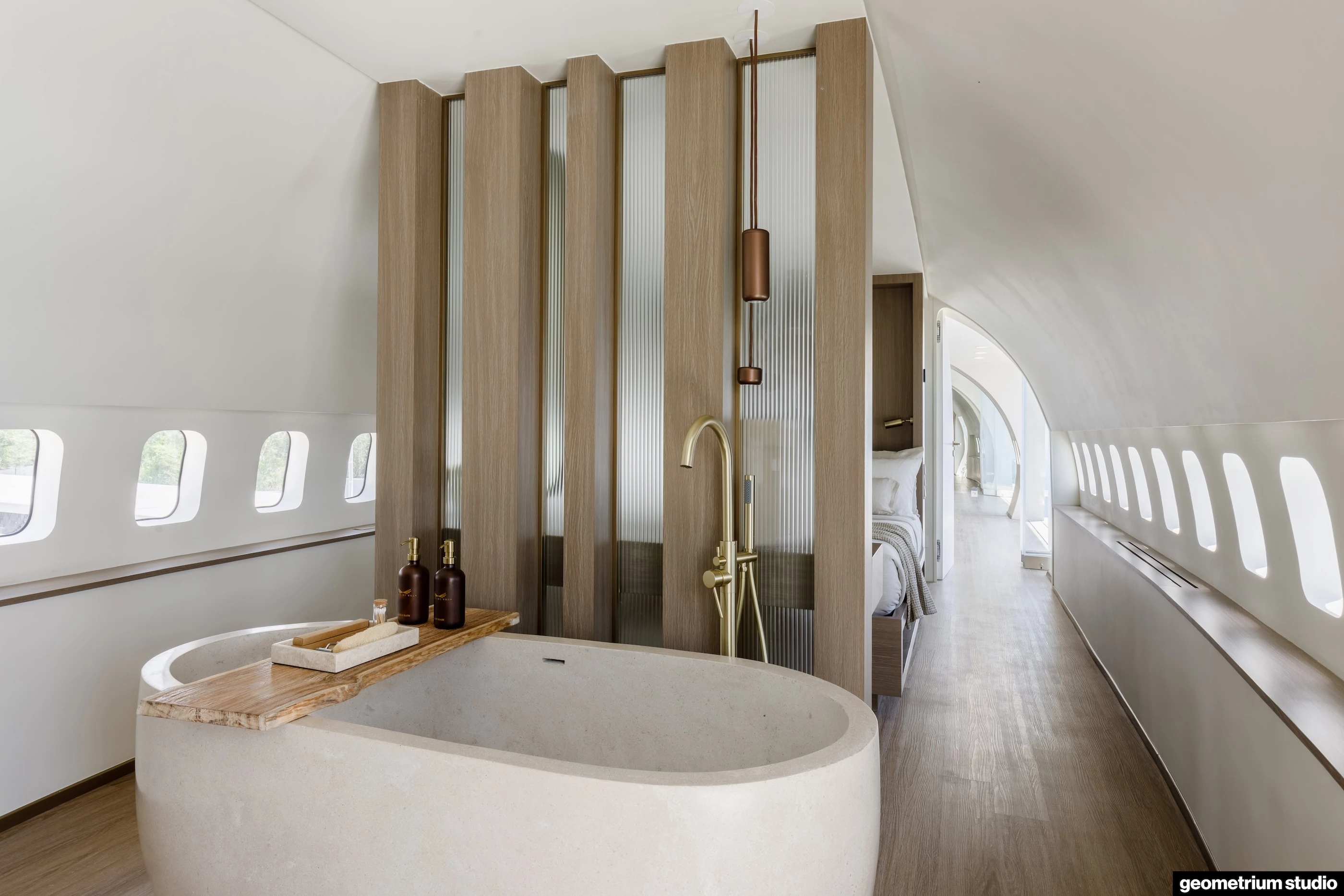 The Private Jet Villa's second bedroom features a freestanding stone tub