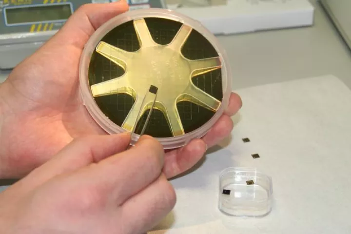 One of the DNA-reading chips, displayed against the prototype device (Photo: Imperial College London)