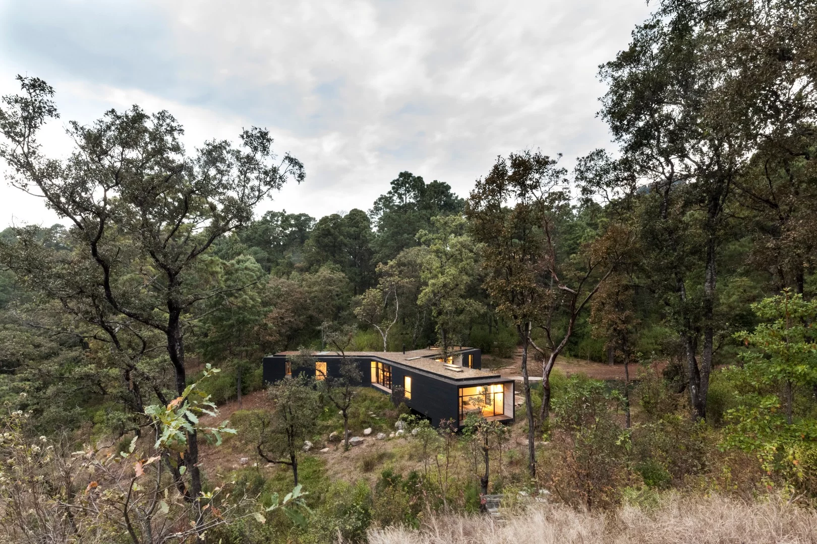 Tucked away in the wooded hillside near Mexico’s Valle de Bravo, a unique new tripod-shaped home has taken shape