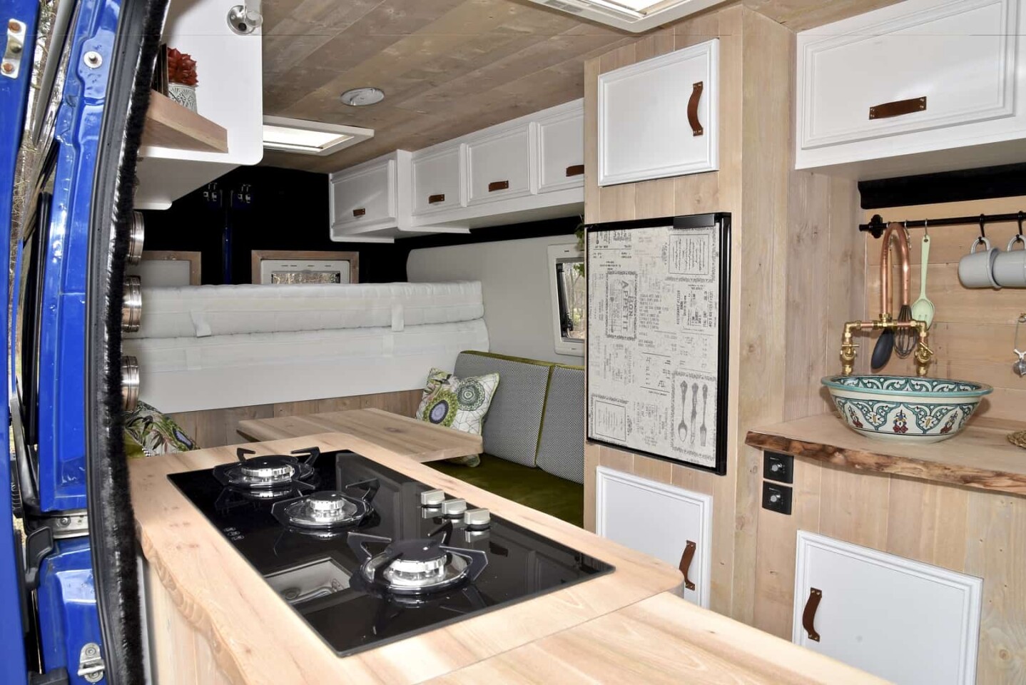 The triple-burner stove and refrigerator create a functional kitchen