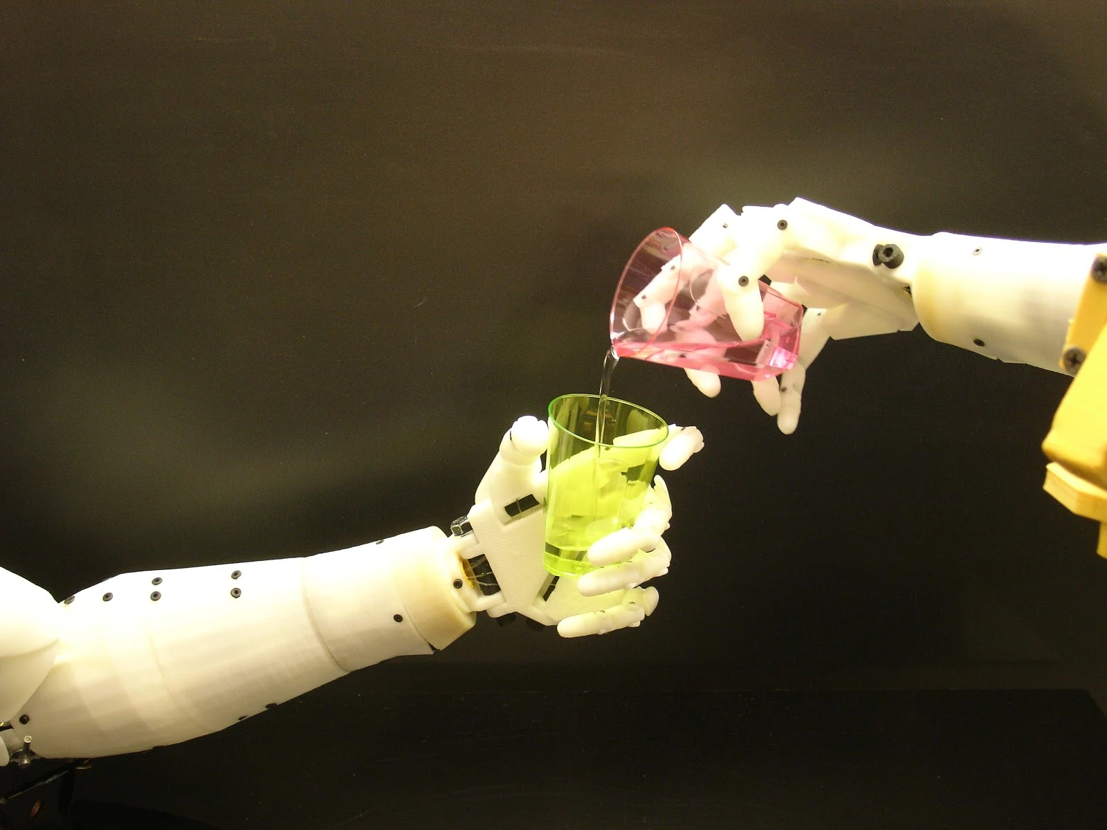 A pair of InMoov arms pour a drink for one another