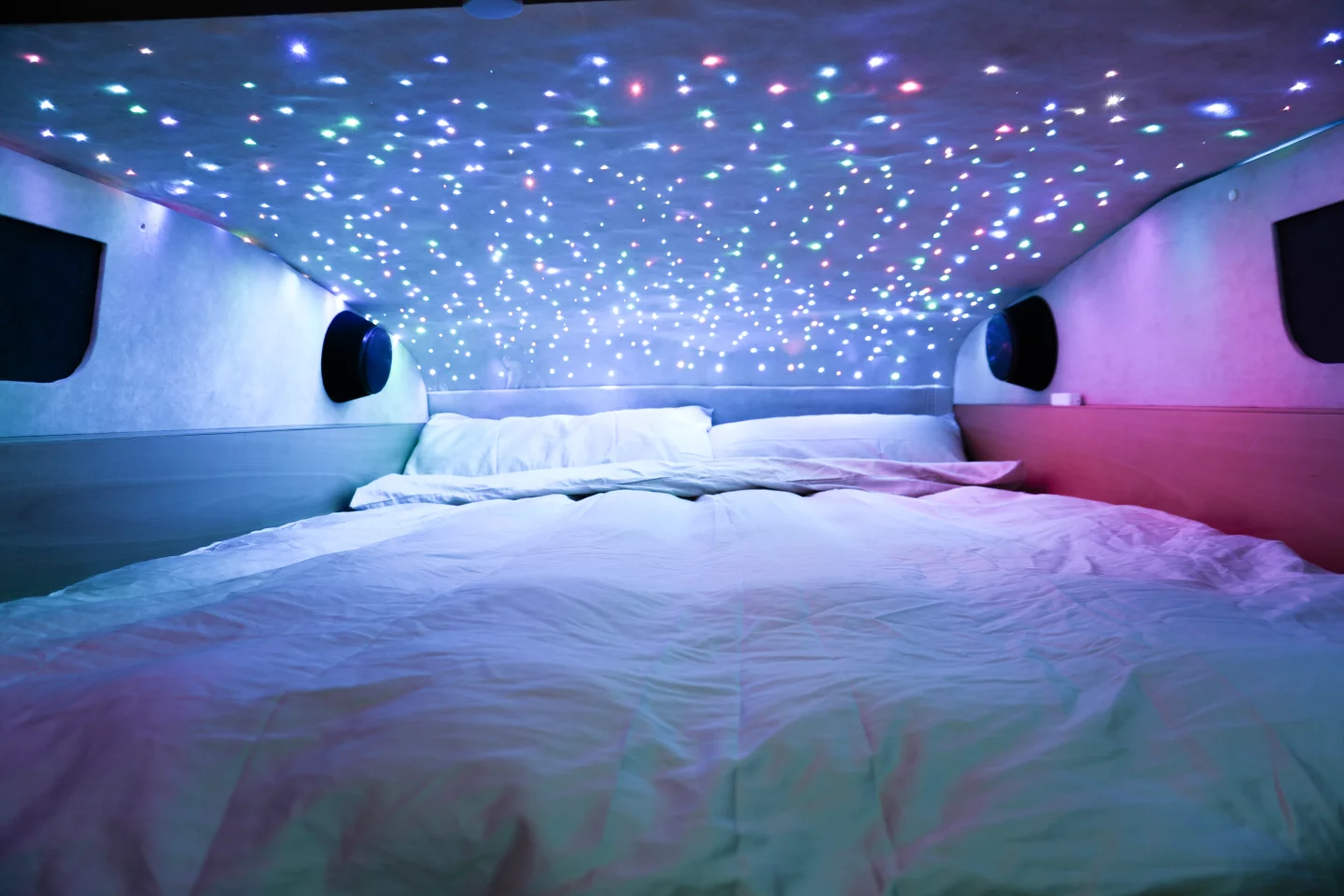 The elevated bedroom areas in the high roof feature a starry headliner, sound system, carbon fiber framed beds and side windows