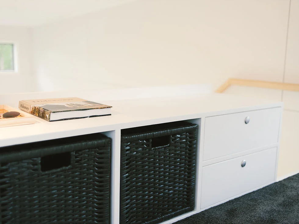 The Buster Tiny House's loft bedroom has integrated storage space