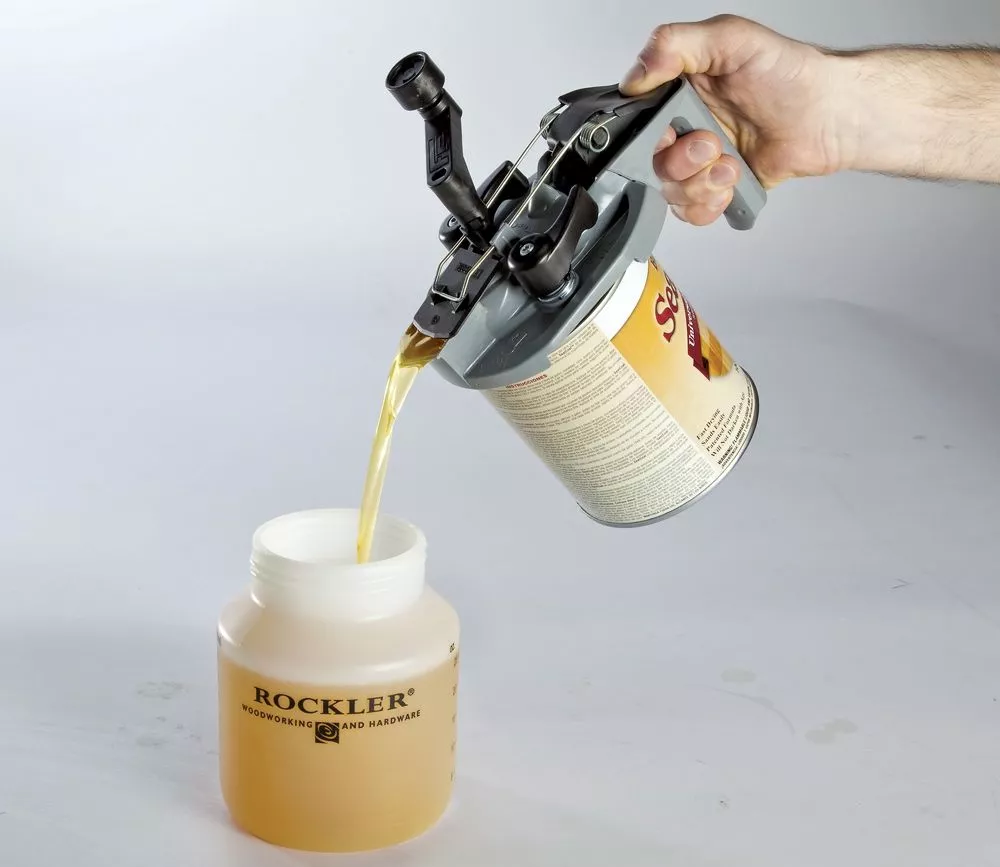 The paint can be poured cleanly from the spout while holding the pistol grip handle and pushing a lever
