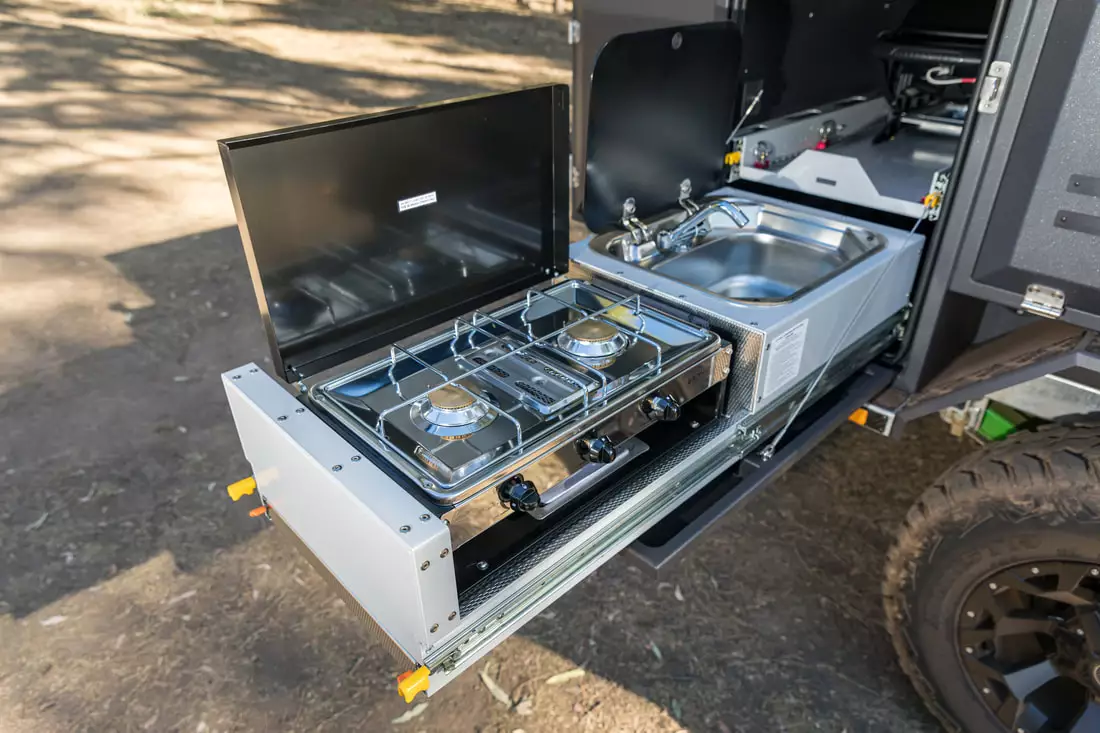 Stainless steel sink and dual-burner stove with grill below