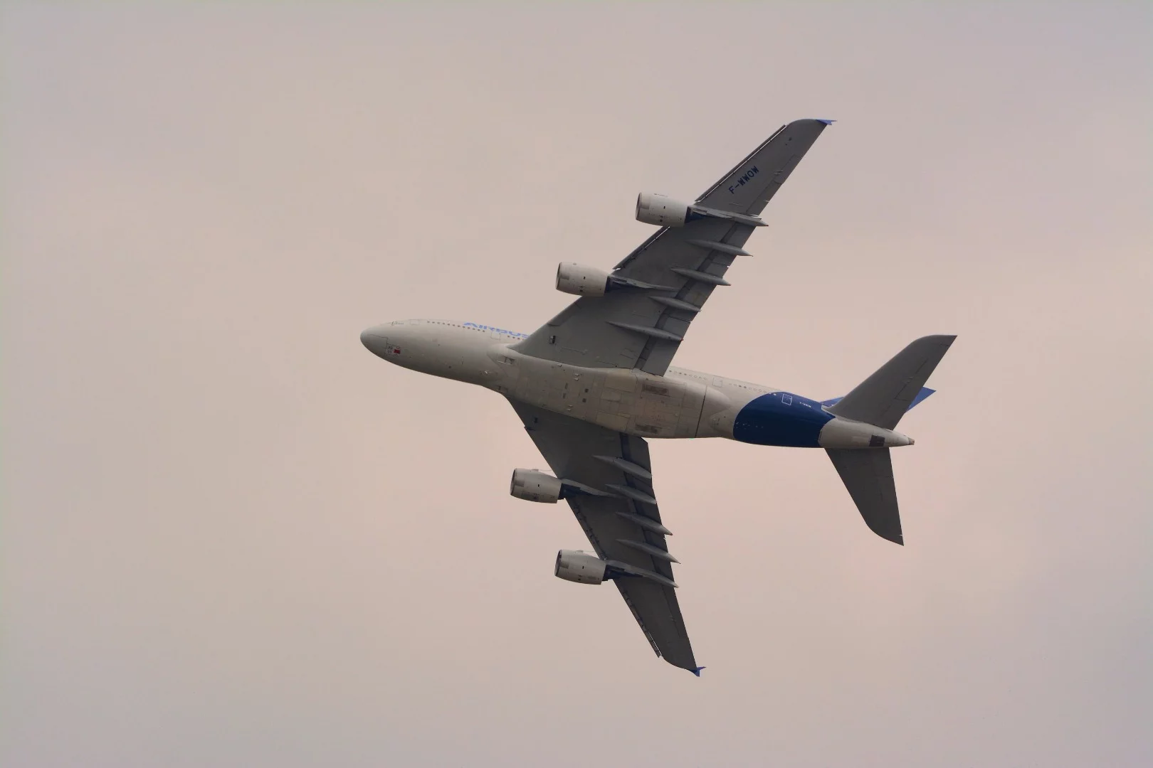 An Airbus A380 passenger jet flying by the Press Center on a cloudy day at the Paris Air Show