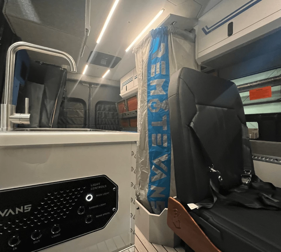 This picture of the Oasis camper van better shows the shower curtain meeting the floor plan box below