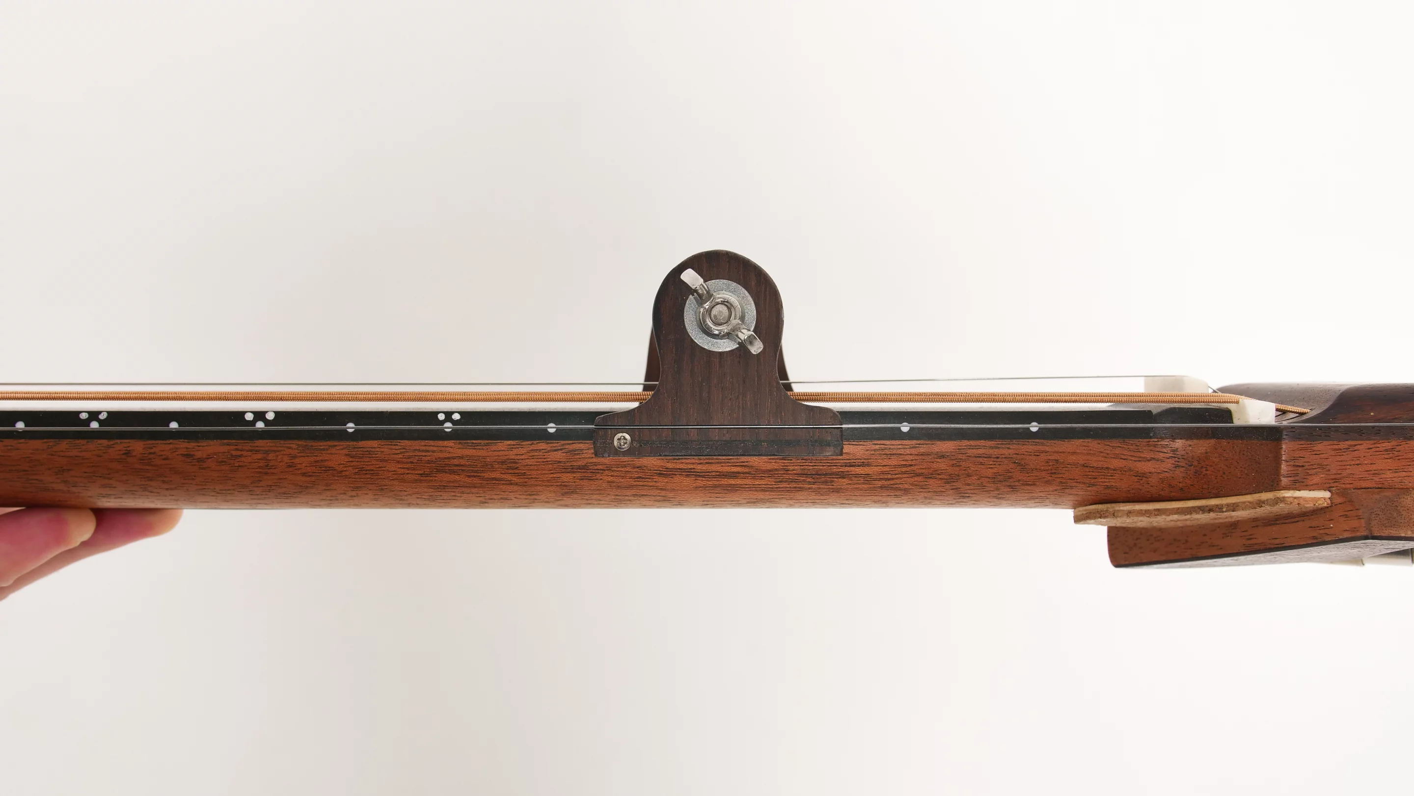 The slide mechanism run along tensioned string guides, and will stay in position during play to let notes ring out