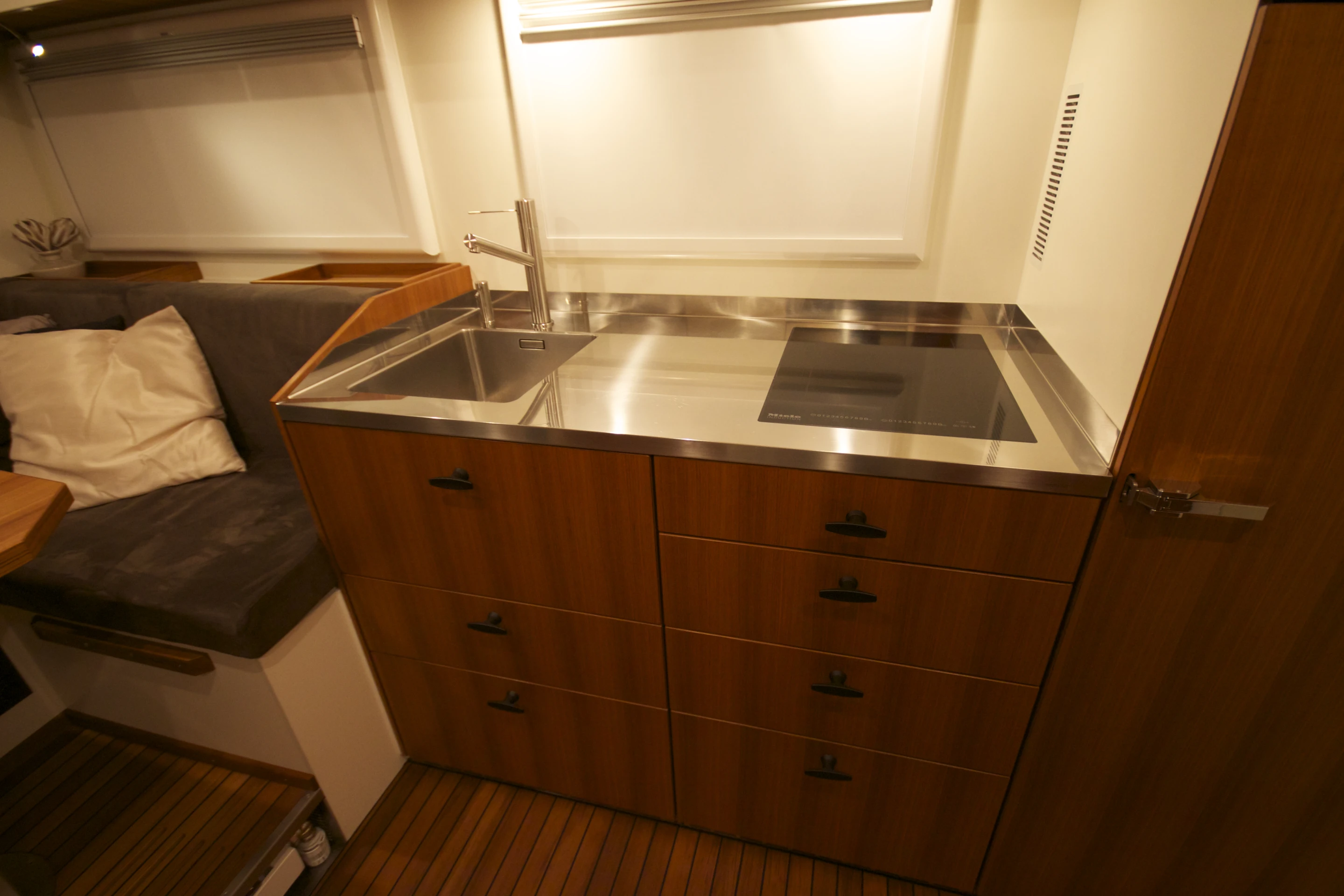 The kitchen area includes a sink and induction cooktop