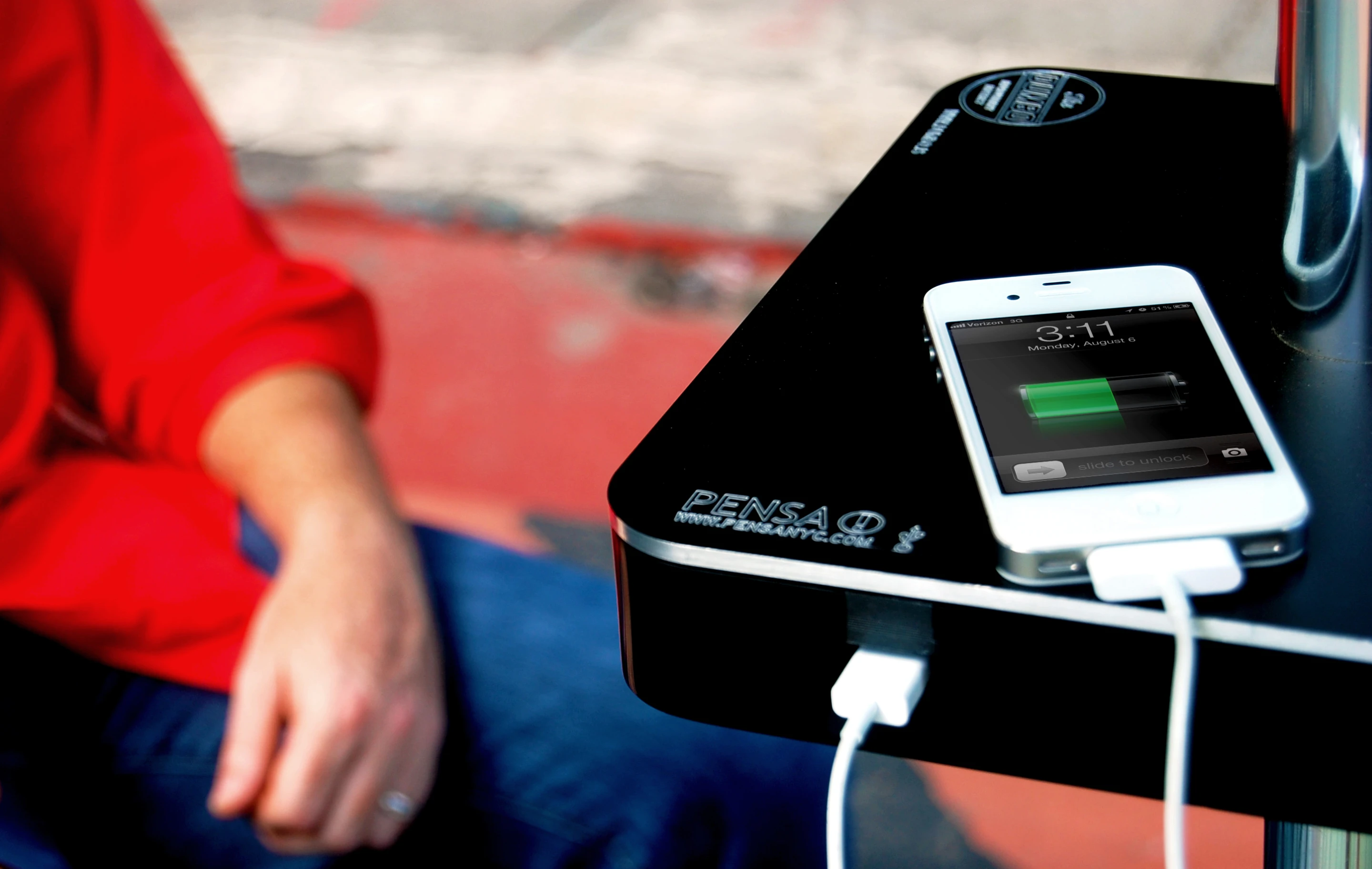 An iPhone being charged by a Street Charge prototype from Pensa