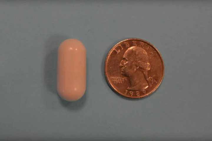 One of the vibrating capsules, with a quarter for scale (Photo: Digestive Disease Week)