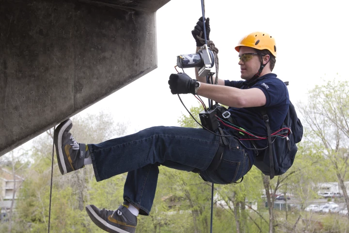 Engineering student Brady Morton uses the winch device to ascend a tower