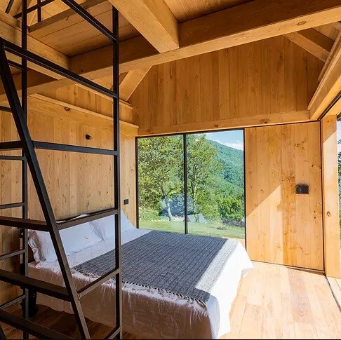 The interior of the dwelling boasts a minimalistic design and stretches across two levels, providing accommodation for up to four guests