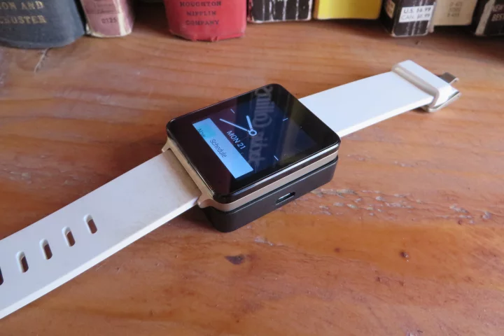 The G Watch atop its charging station, sans USB cord