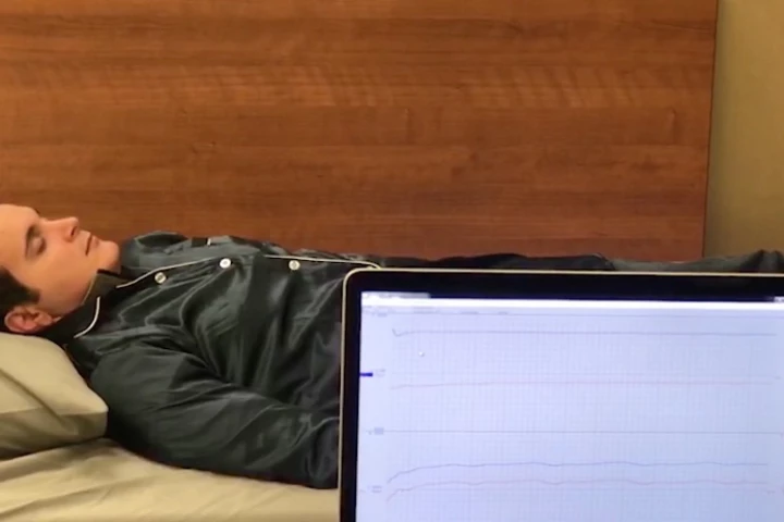A volunteer helps test the Phyjama – their sleep data is visible on the computer screen
