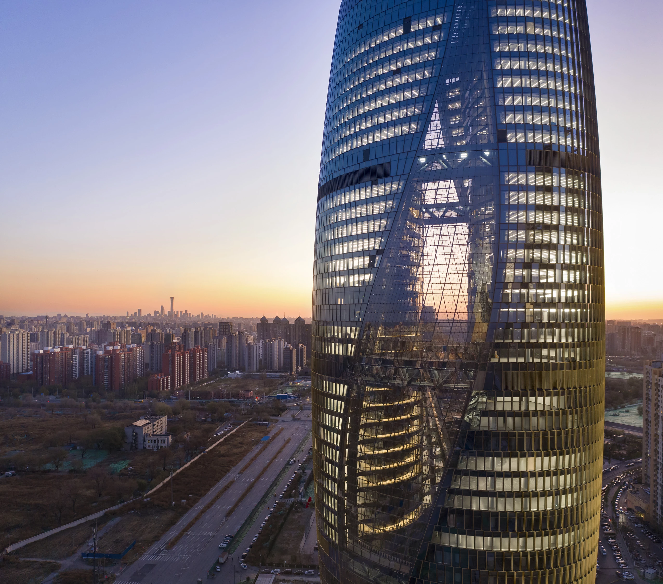 "Straddling this tunnel, the tower's design divides its volume into two halves enclosed by a single facade shell," explains Zaha Hadid Architects