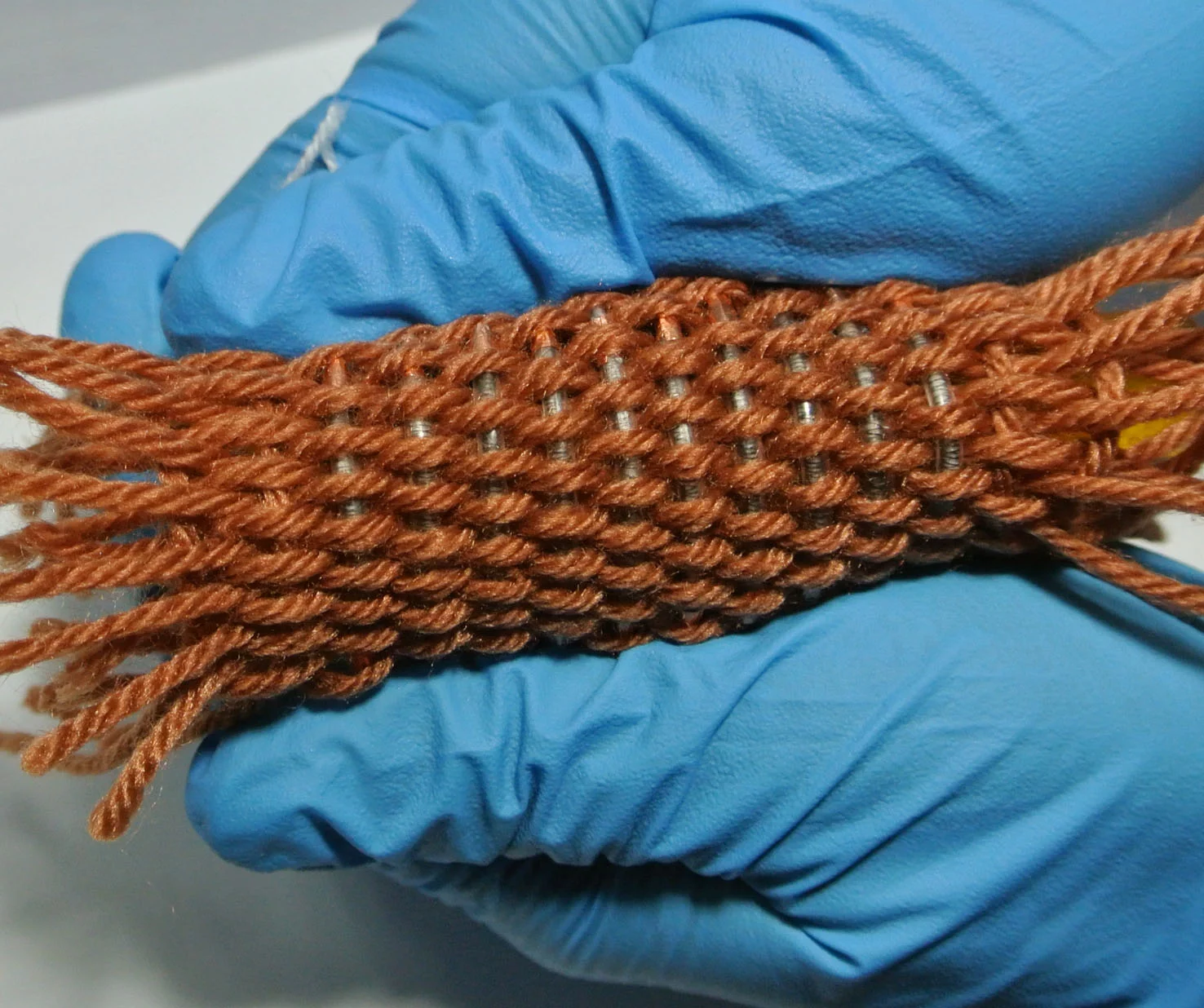 The fiber-shaped Li-ion batteries can be woven into textiles capable of powering wearable electronic devices (Photo: Wei Weng)