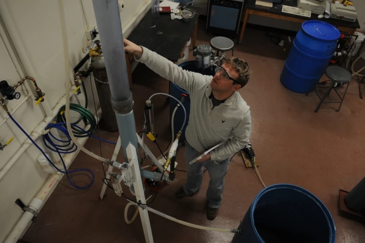 The CO2 collecting smokestack with Michigan Tech chemical engineering PhD student Brett Spigarelli (Photo: George Olszewski)