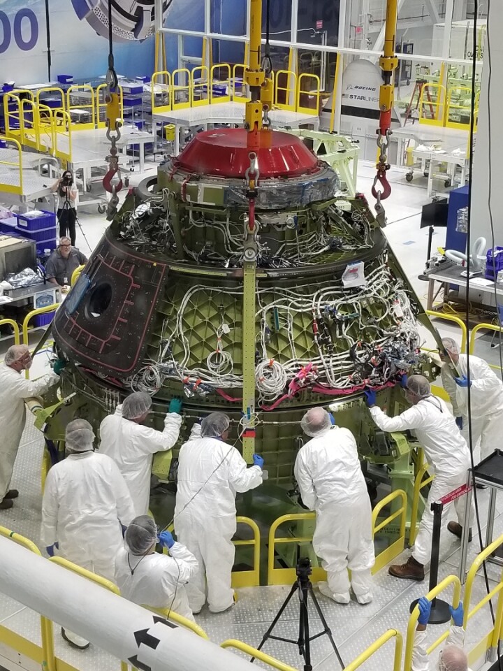 Boeing technicians lower the Starliner upper dome to the lower dome before bolting and sealing the pressure vessel