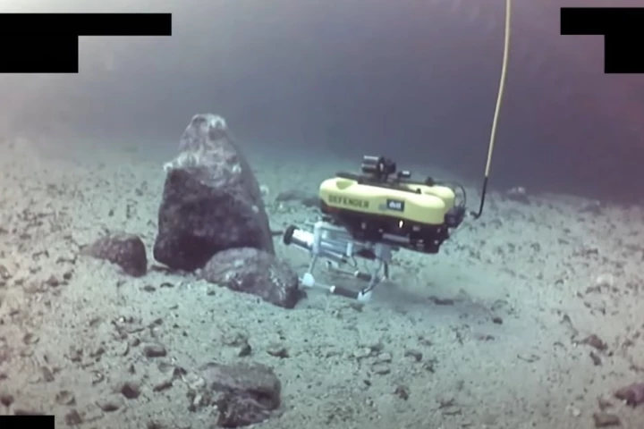 Robot laying an explosive charge on a pipeline "threat"