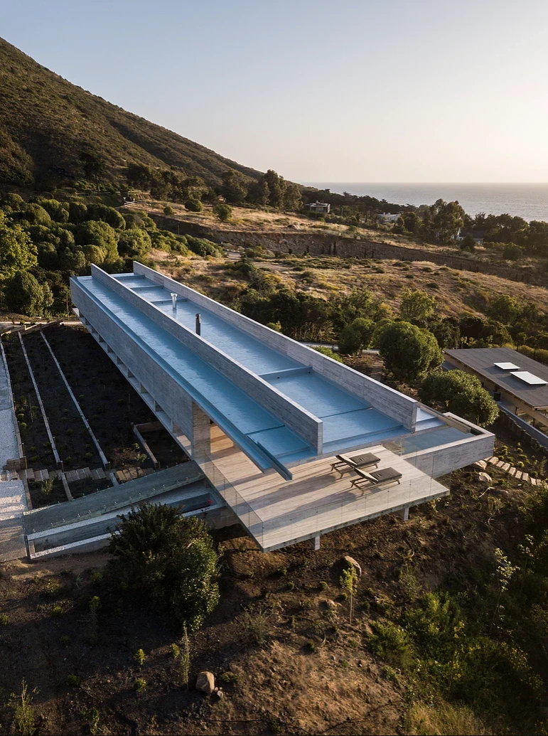 La Casa H is built into hills around the coastal town of Zapallar, leaning on a set of four monster reinforced concrete beams running the length of the structure