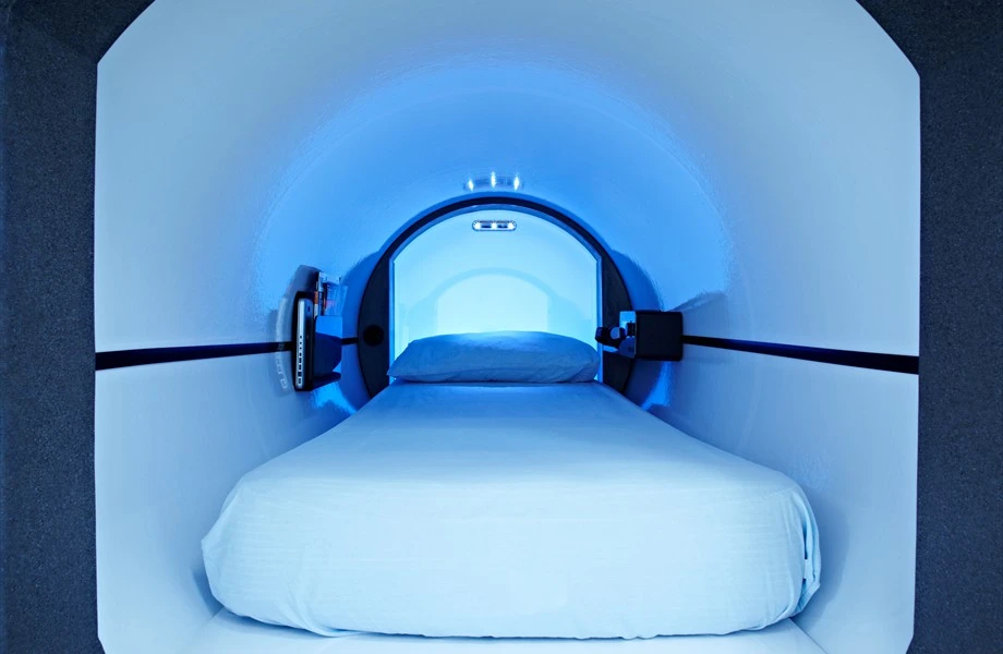 Inside Podtime's modular sleeping pod, with room for reading material and digital entertainment