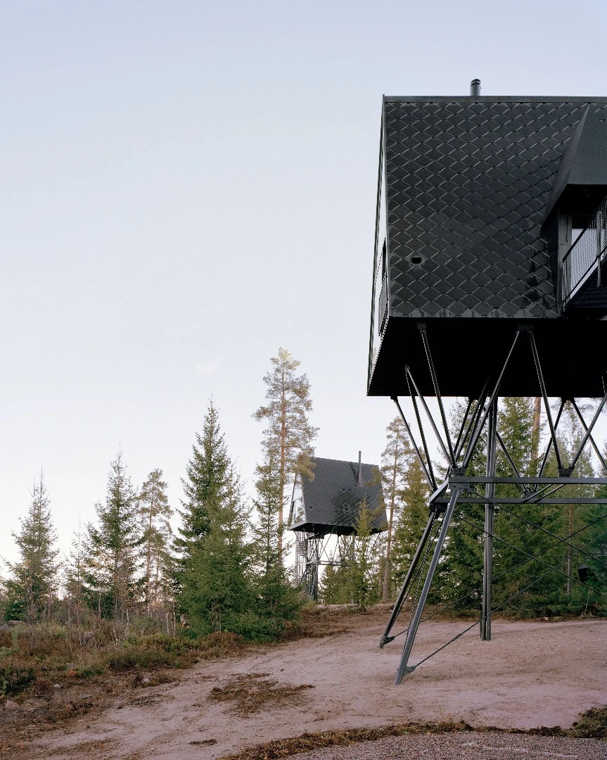 The Pan Treetop Cabins project includes two cabins in a forested area of Norway, near the Swedish border