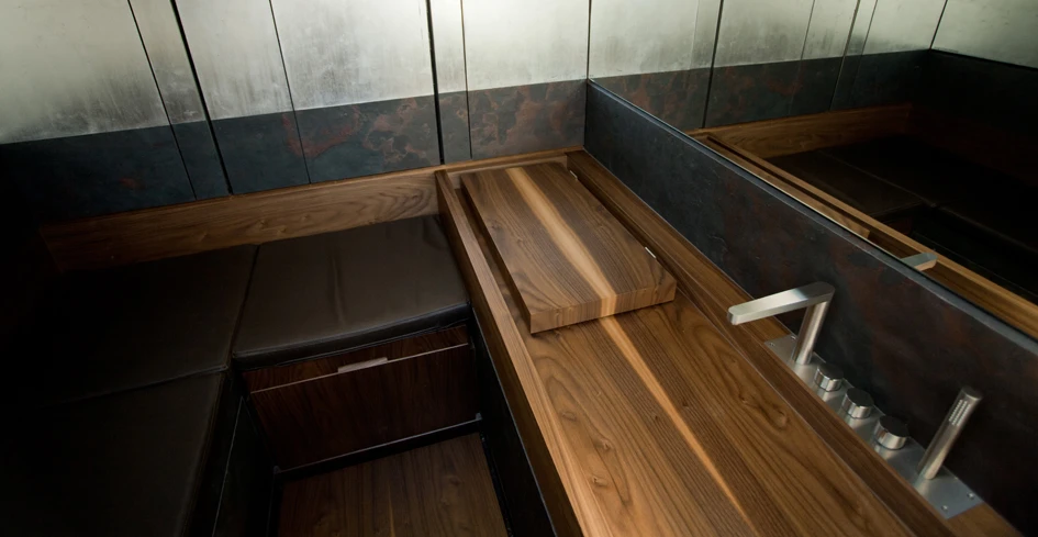 Below deck features cushioned seating and a wooden work bench
