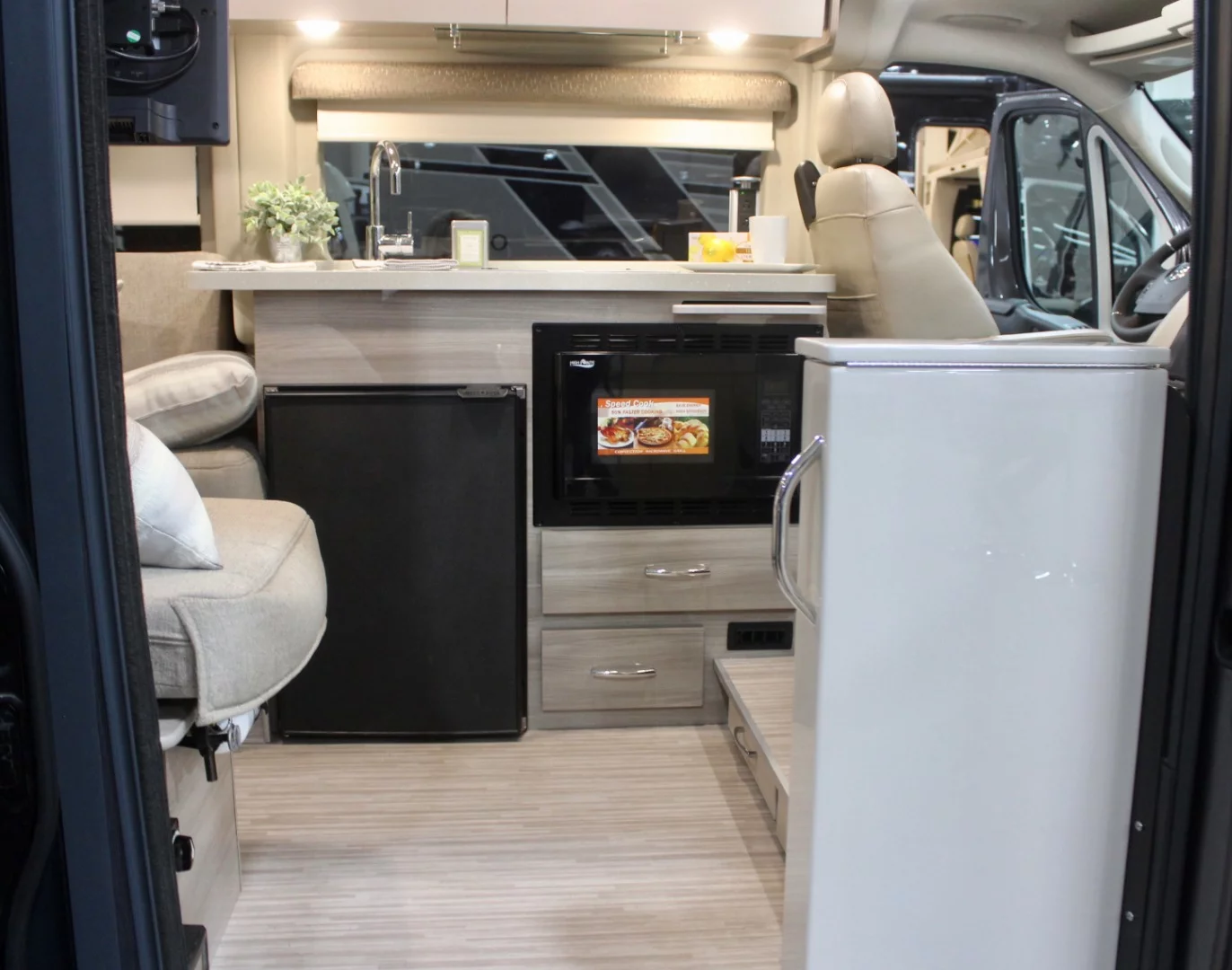 A look inside the Thor Sequence concept, where the kitchen block stands directly across from the door and behind the cab — we didn't realize there was a slide-out pet tray at the time, but that's integrated into the step from cab to cabin you can see on the lower right