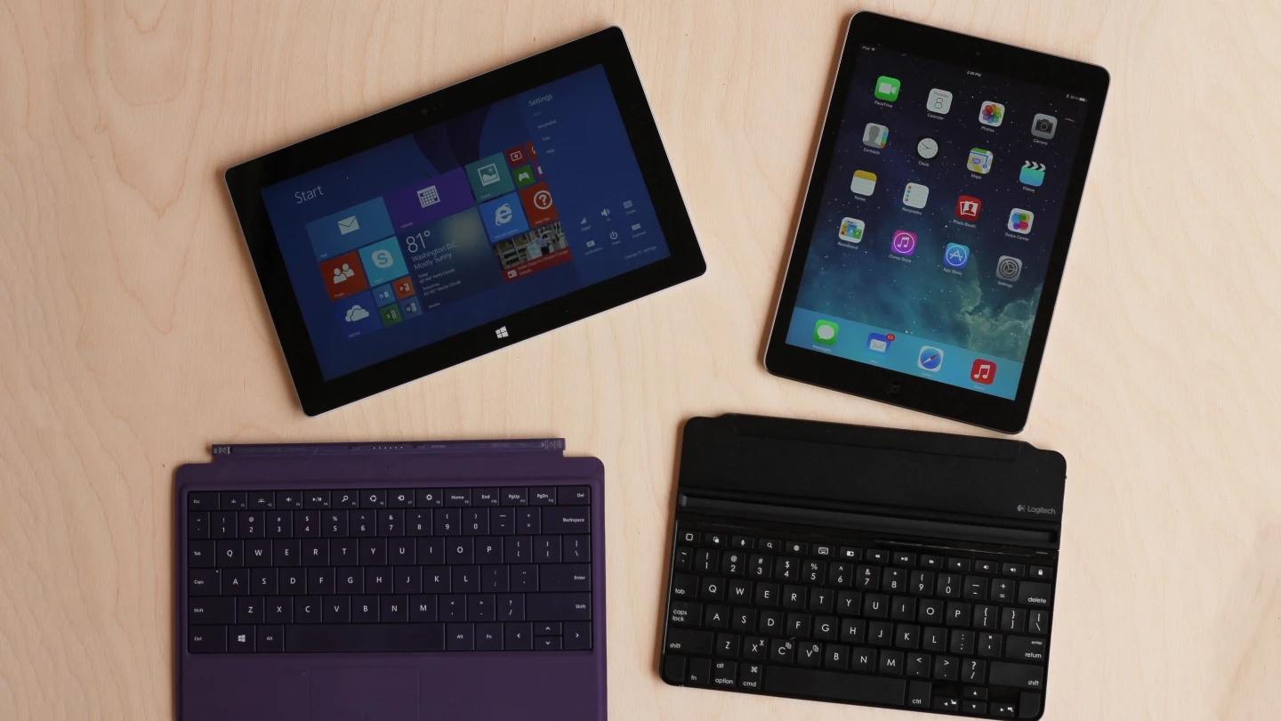 The Surface Pro 2 (with Power Cover) and iPad Air (with Logitech Ultrathin Keyboard Cover)