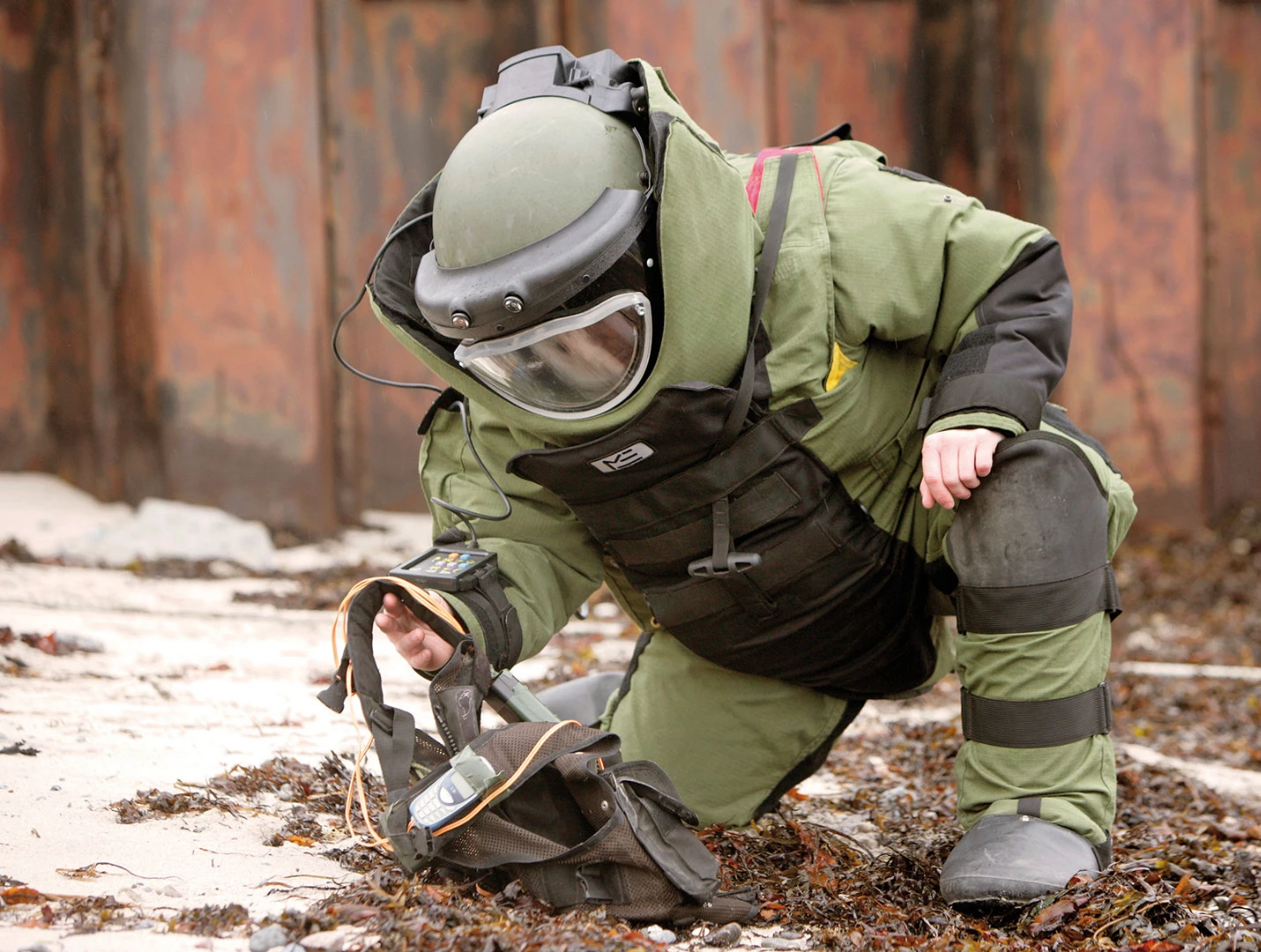 A bomb expert inspects a suspicious vest for explosives