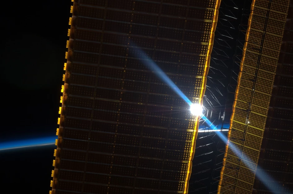 The Sun peeking through one of the ISS's current solar array panels, captured back in June 2012