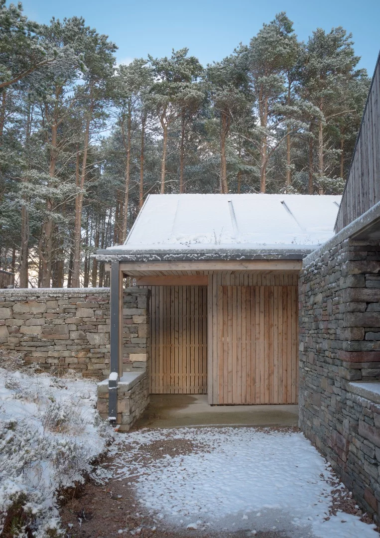 Lochside House is finished in Scottish larch and surrounded by a drystone wall
