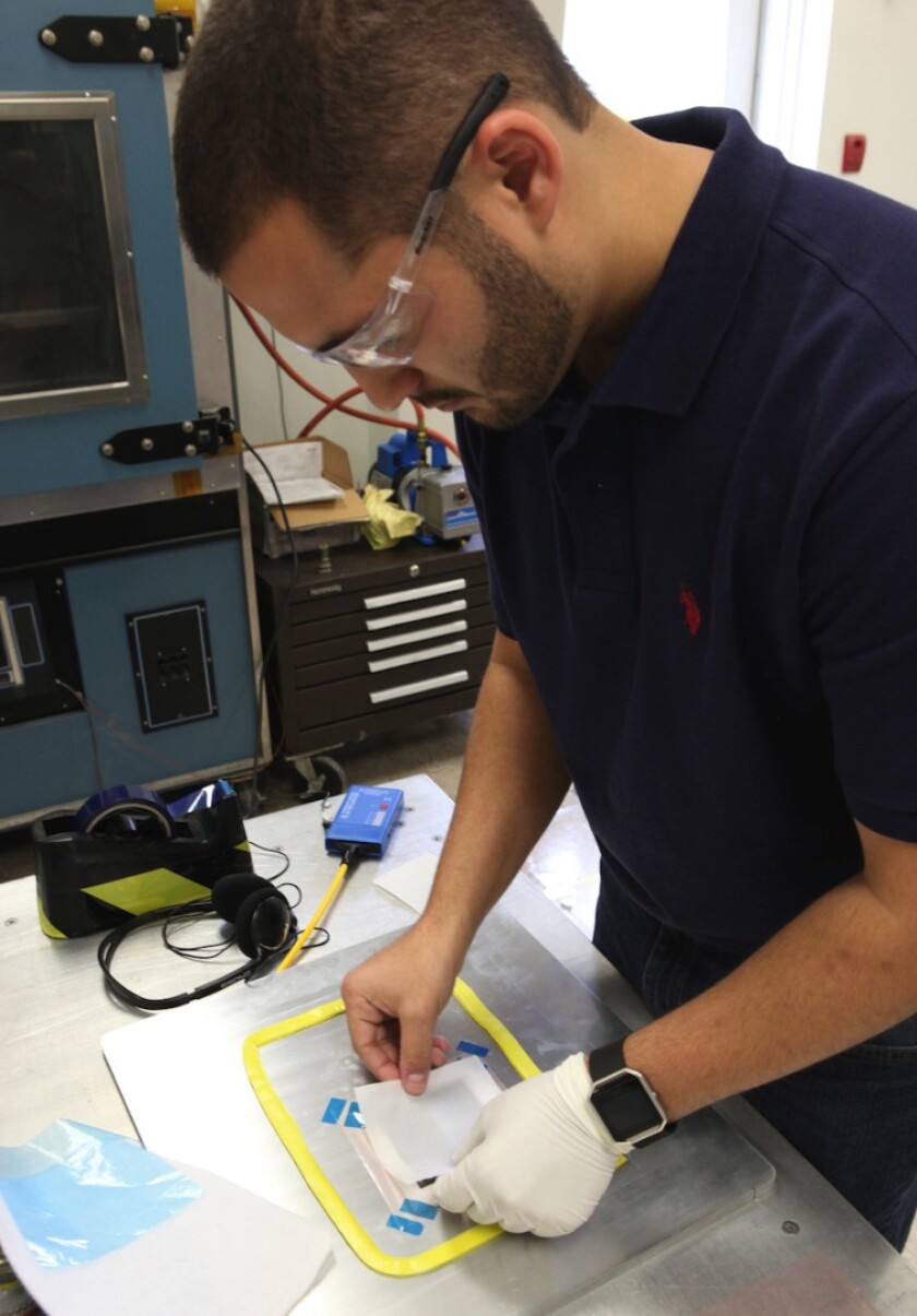 Daniel Perez, from the University of Miami, makes the outer layers for the batteries by compressing carbon fiber