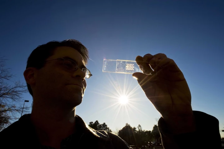The solar cell test prototype with a microscale lens array fastened above it - the cell and lens help create a concentrated photovoltaic unit (Image: Randy Montoya)