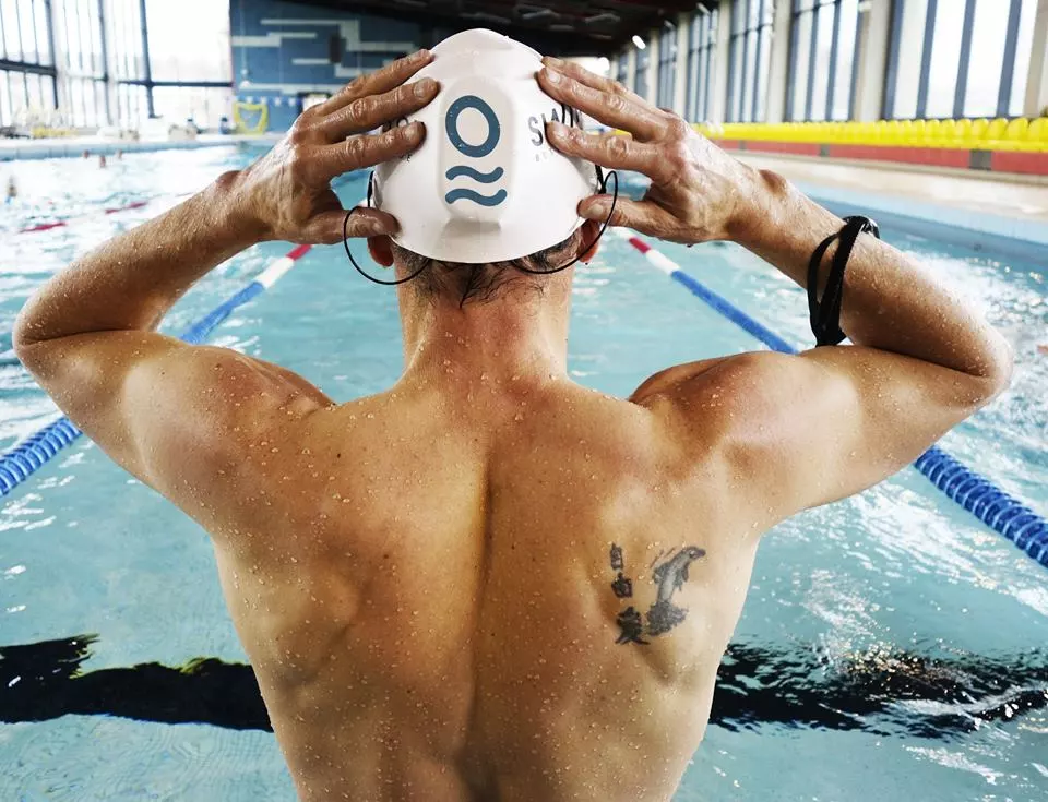 The SwimBot is mounted beneath the user's swim cap