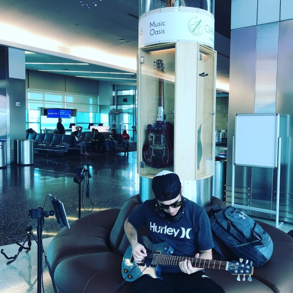Rocking out at the airport with the Ascender premium travel guitar