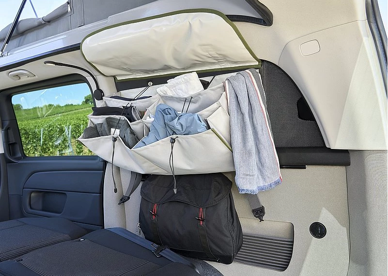 Removable organizer bags replace a hard-walled cabinetry in providing storage space