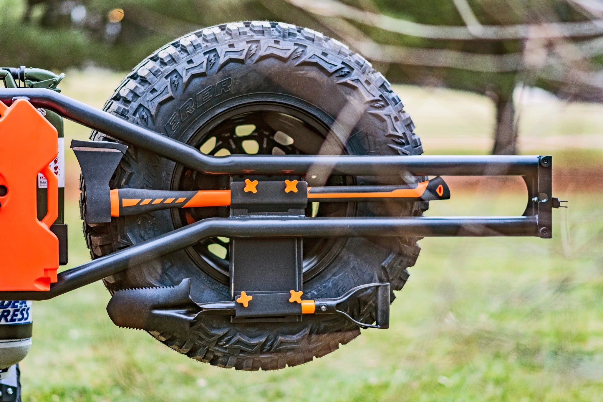 The swing-out spare tire rack also holds an axe and shovel
