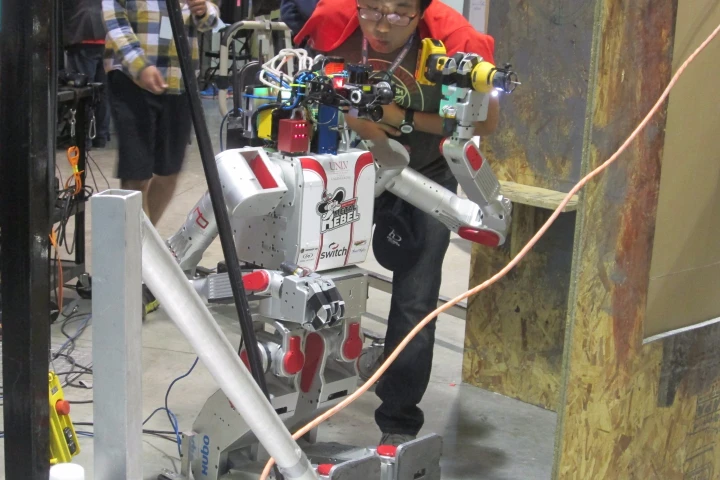 The robot DRC-Hubo (aka "Metal Rebel") receives some TLC at the DARPA Robotics Challenge