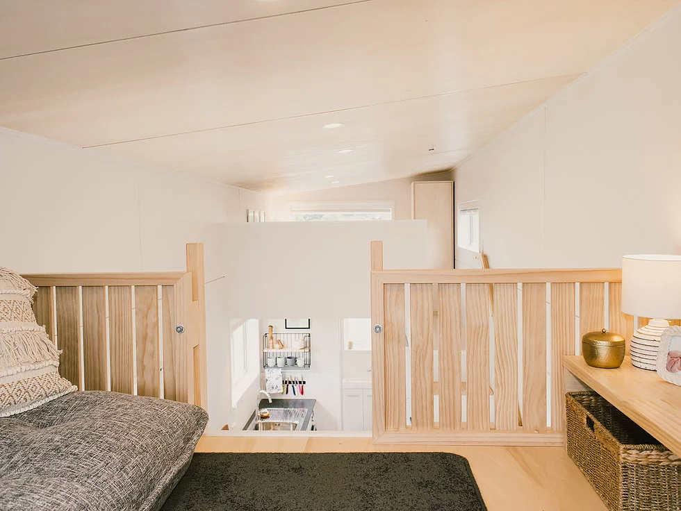 The Archer Tiny House features an upstairs loft space used as a living room/guest room