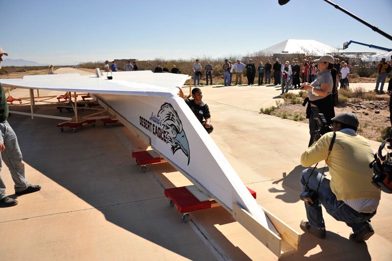 Arturo Valdenegro, posing with the giant paper airplane based on his design