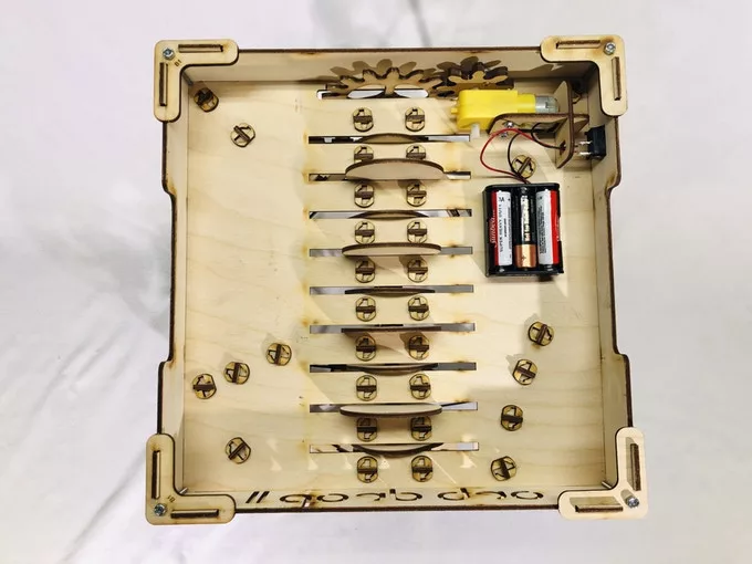 An electric motor drives a gear which in turn drives the cam shaft that takes the marbles to the top of the run