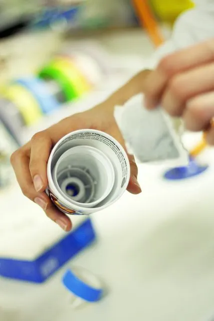 The tea bag being put in place near the mouth of the special water bottle